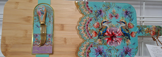 Decorative cutting board with floral design and knife on a white surface