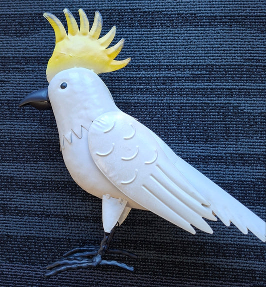 White cockatoo figurine with yellow crest on a dark textured background
