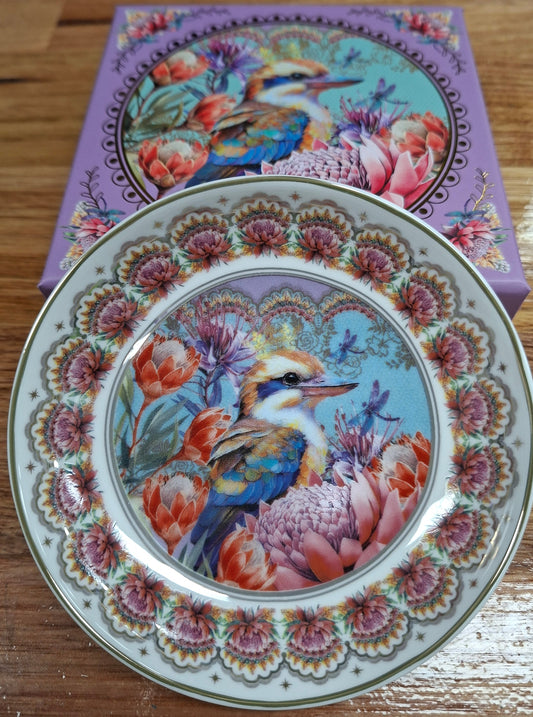 Decorative plate with bird and floral design on a wooden surface