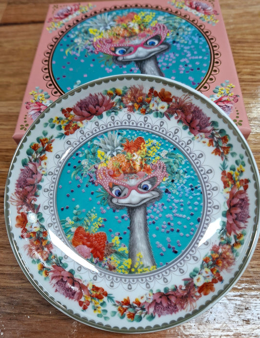 Decorative plate with a colorful design of an ostrich on a wooden surface
