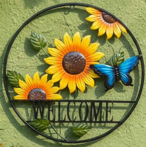 Decorative wall art with sunflowers, a butterfly, and 'WELCOME' text on a green background.